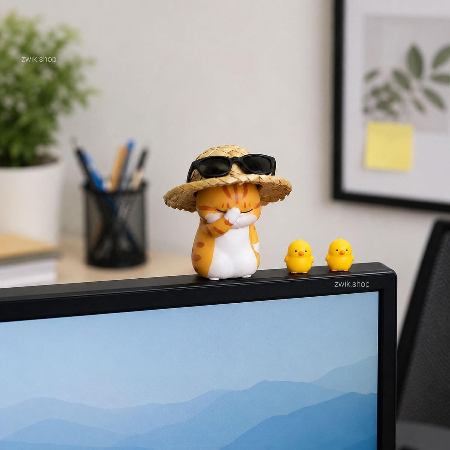 Sunhat cat set perched on a monitor